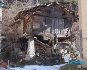 Wooden_horreo_on_stone_pegollos_has_two_doors_and_is_deteriorated_PIcos_de_Europa_León