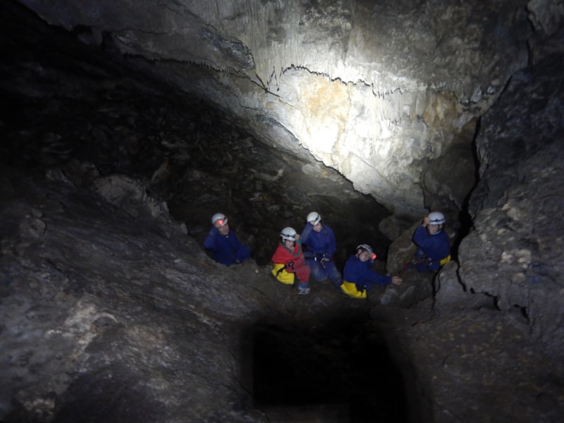 grupo haciendo espeleología dentro de una cueva en cordillera cantábrica